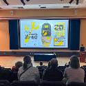 A projector screen showing a student's yellow and black backpack design