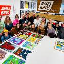 A group of people standing around a table with poster designs on it