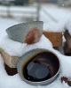 blue and brown ceramic bowls surrounded by snow