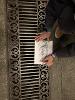 student creates a rubbing of an interesting grate pattern in Turin Italy