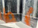 Detail shot of an accordion book featuring abstracted, orange figures printed on top of a deconstructed subway car image. Five figures are visible in the chosen detail spot.