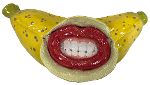 A bright yellow ceramic banana with cartoonish red lips baring a grimace burst out of the side.