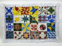 Quilt made out of colorful ceramic tiles with a white lace border.